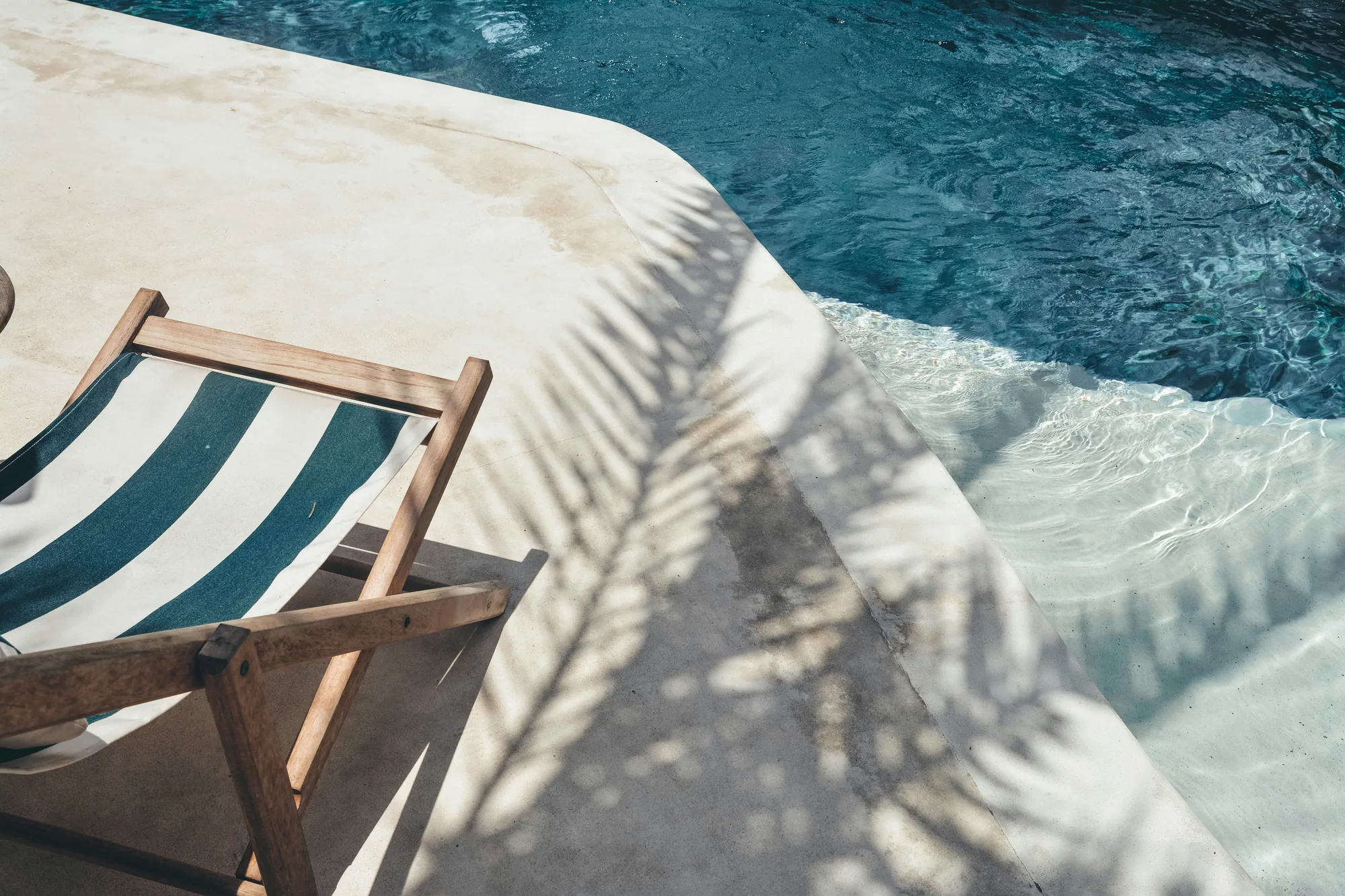 Transat au bord d’une piscine en pierre dans le Golfe de Saint-Tropez